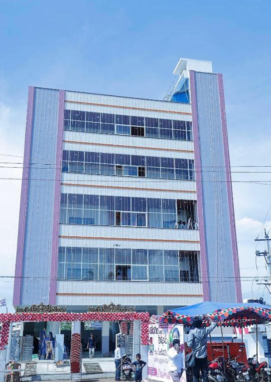 a tall building with a market in front of it at Dove Convention in Machilīpatnam