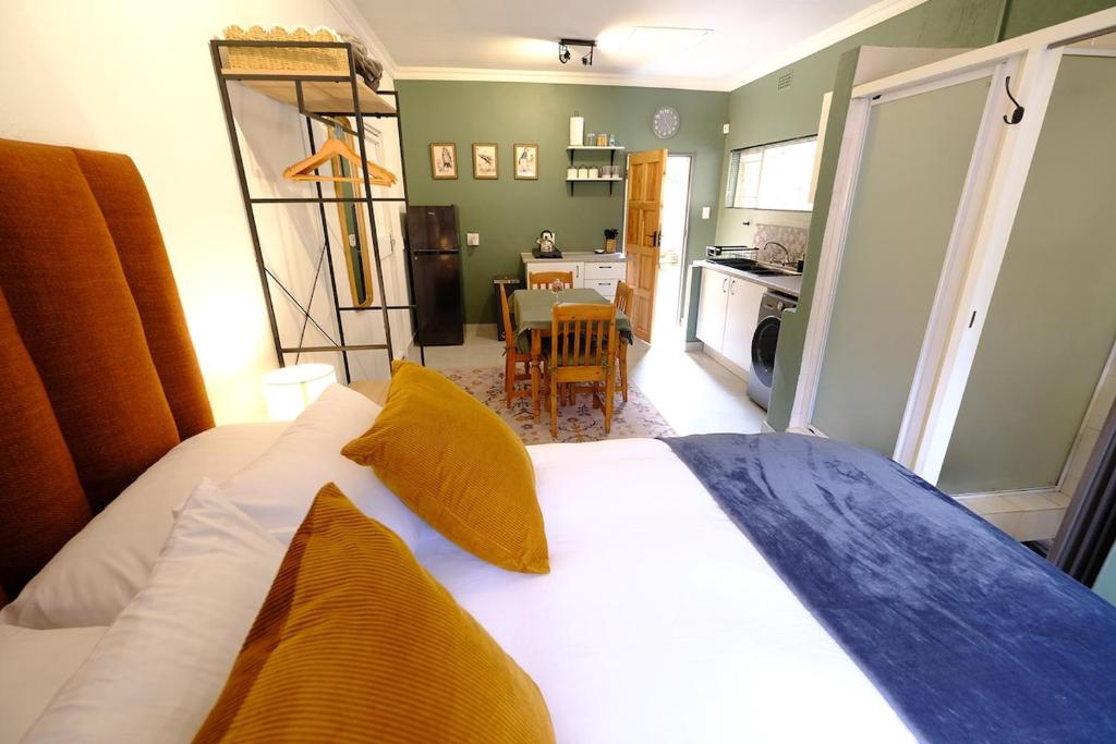a bedroom with a bed and a kitchen with a table at Bucklebury inn in Centurion