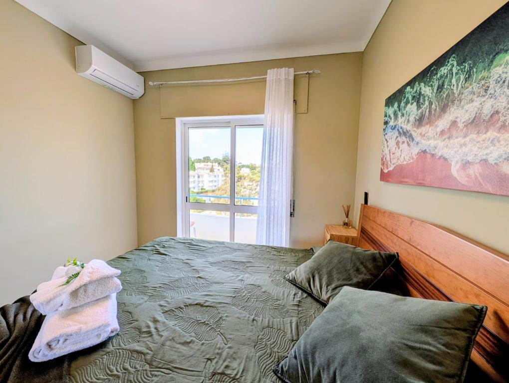 a bedroom with a bed and a window at 4º5 Edificio Mar - Casas & Papeis in Armação de Pêra