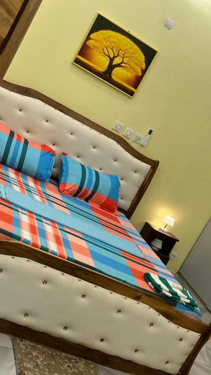 a bed in a bedroom with a picture on the wall at CHAMBREs SALON MEUBLÉ in Yamoussoukro