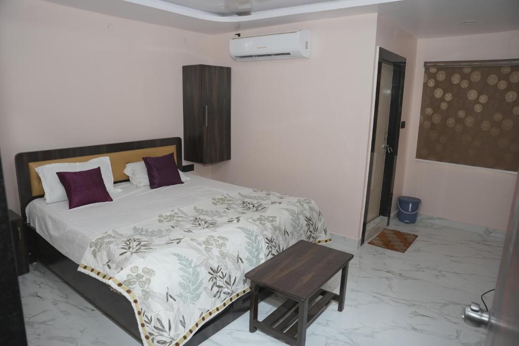 a bedroom with a bed with a table in it at V Rooms in Pendurti