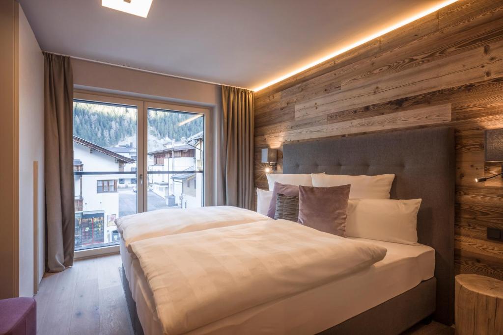 a bedroom with a large bed and a large window at Postresidenz in Mayrhofen
