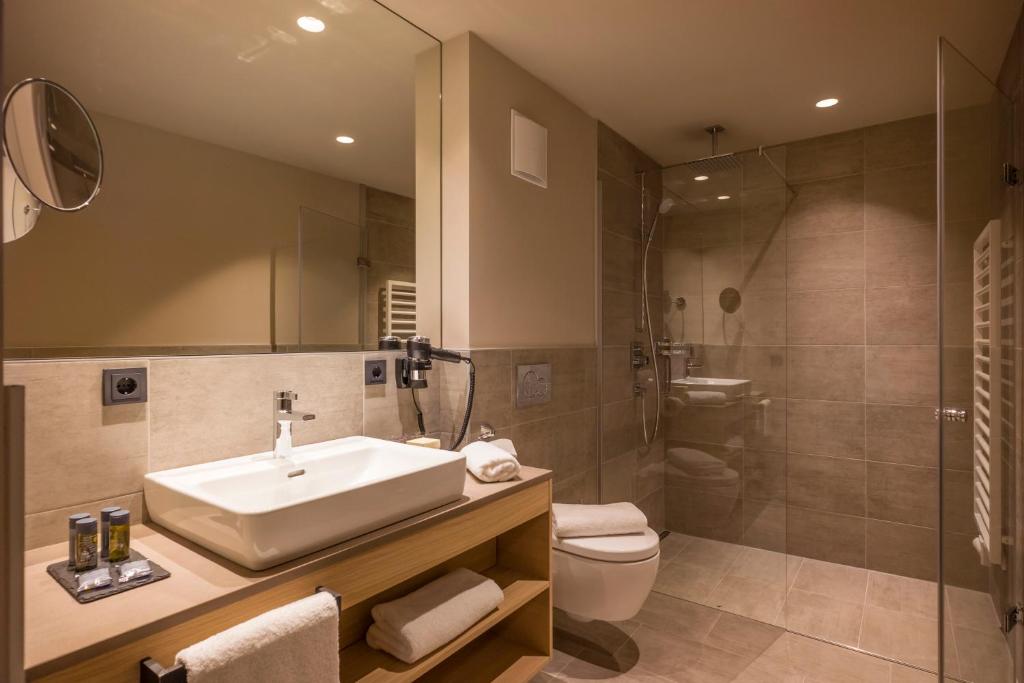 a bathroom with a sink and a toilet and a shower at Postresidenz in Mayrhofen