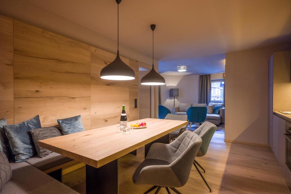 a dining room and living room with a table and chairs at Postresidenz in Mayrhofen