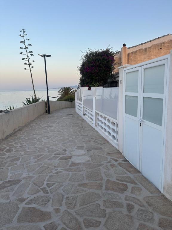 a driveway with a white garage door and the ocean at apartamento peñon de jolucar in Torrenueva