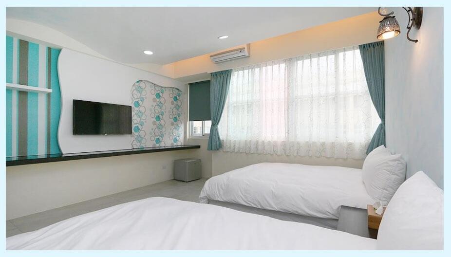 吉安的住宿－小敏&日森民宿，酒店客房设有两张床和窗户。