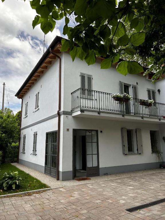 a white building with a balcony on it at Emilia94 in Anzola dell'Emilia