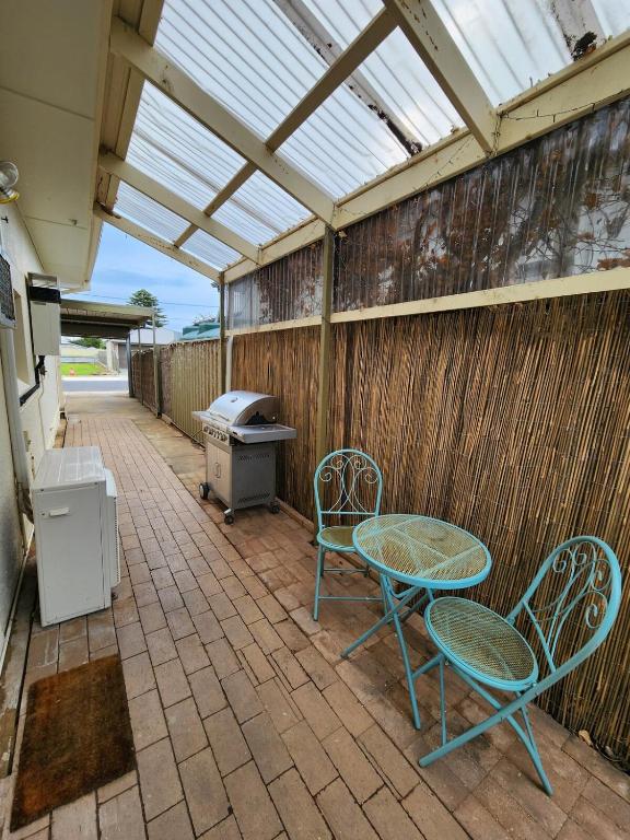 a patio with two chairs and a table and a grill at Entire Unit in Brooklyn Park in West Richmond