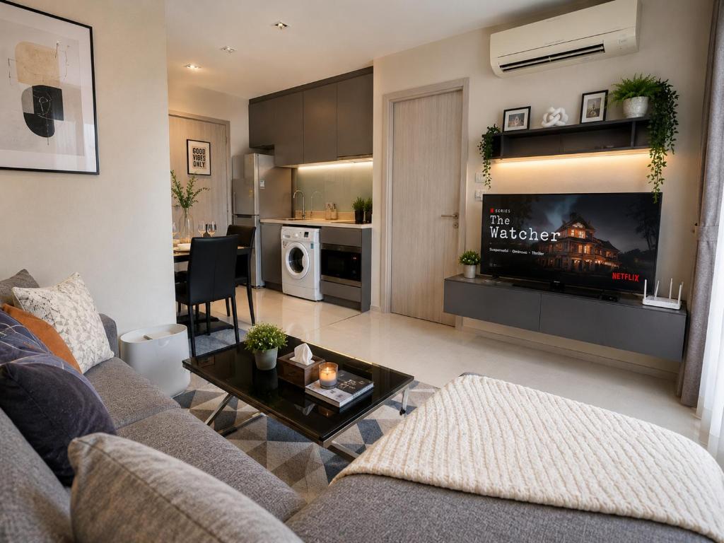 a living room with a couch and a tv and a table at Ultra luxury Condo in Bangkok
