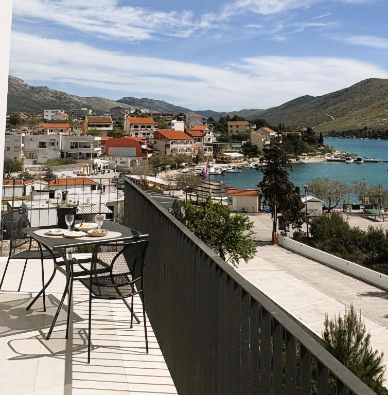 a balcony with a table and a view of the water at Arte Oliva in Grebaštica