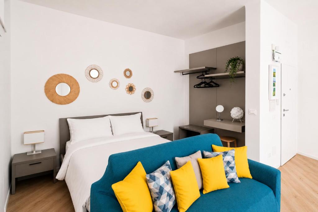 a bedroom with a bed and a blue couch at Yellow Apartment in Bari