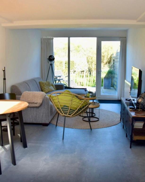 a living room with a couch and a chair at Eb & Vloed in Petten