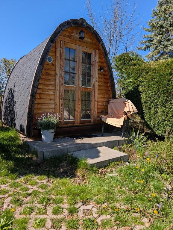 a round house with a window and a chair outside at Glamping im Tiny House - nahe Dresden in Freital