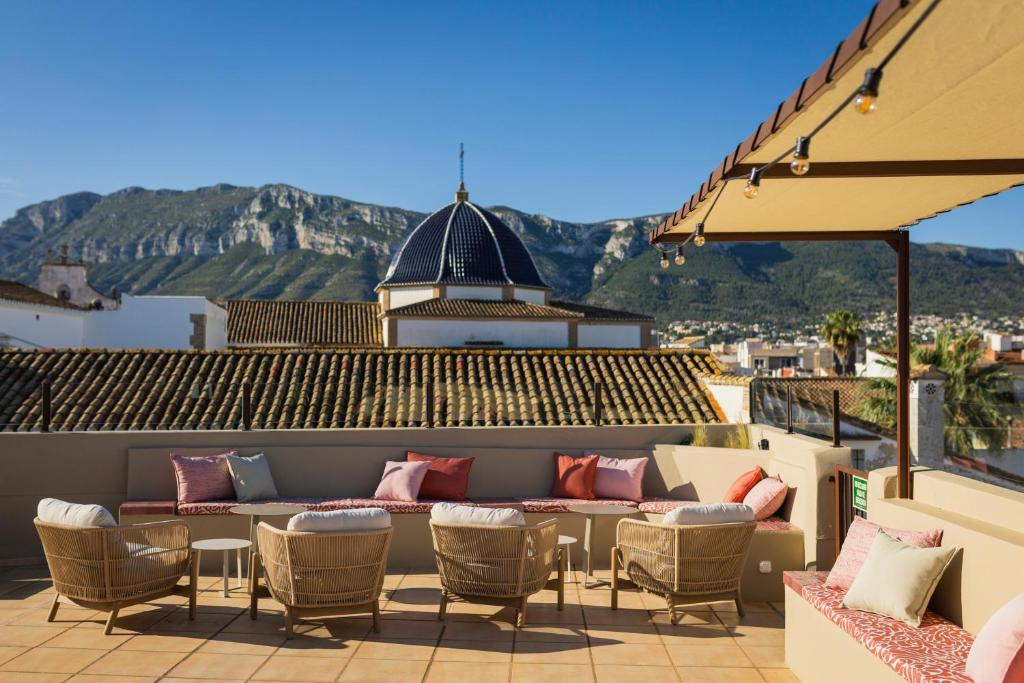 a patio with a couch and chairs on a roof at Hotel Nou Romà in Denia