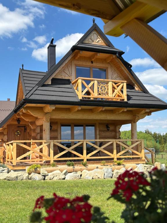 a large log cabin with a black roof at Domek z Sercem in Pieniążkowice