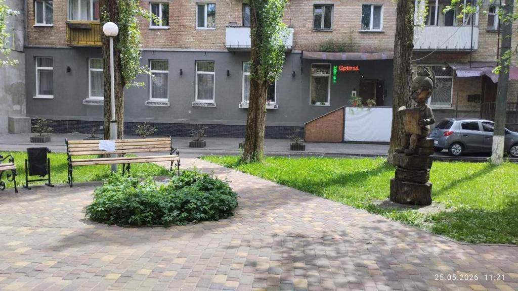 a park with a bench and a statue in the grass at Optimal in Vyshneve