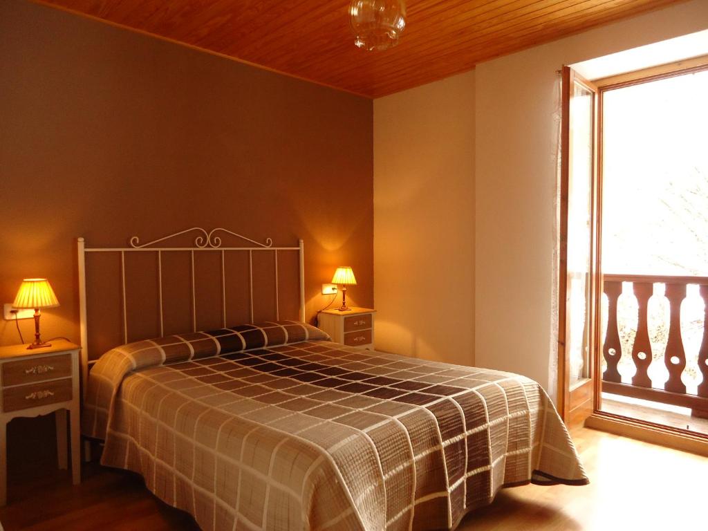 a bedroom with a bed and a large window at Apartaments La Llucana in Barruera