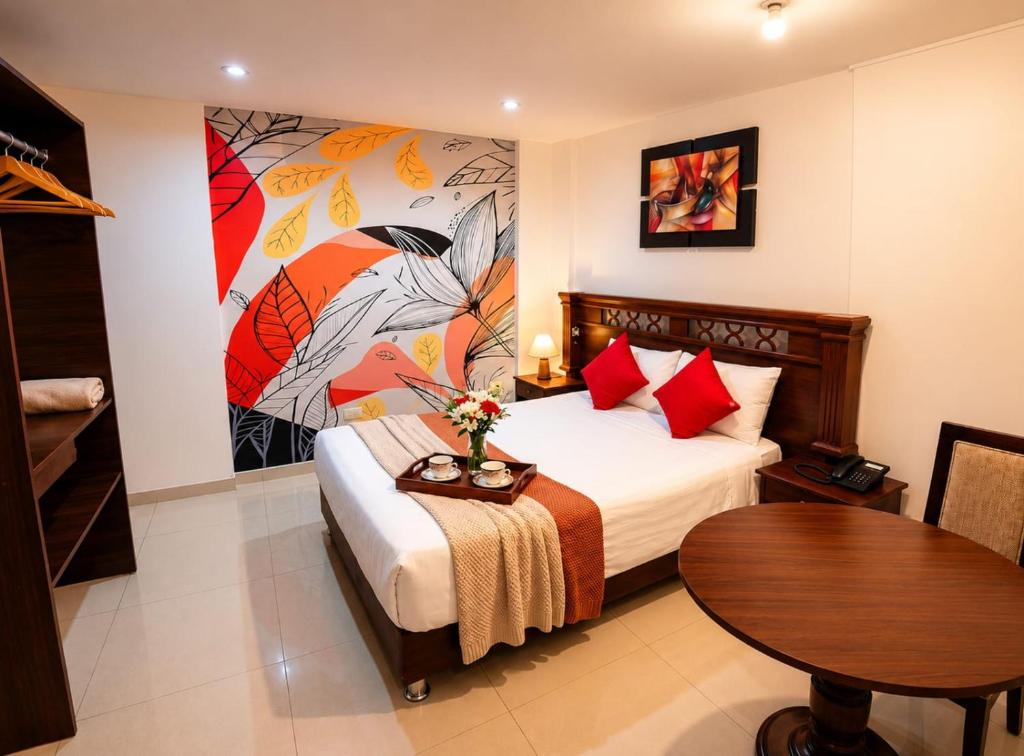 a bedroom with a bed with a table and a painting at Mandala Rooms & Services in Arequipa