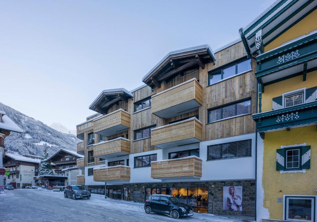 a building with wooden balconies on a snowy street at Postresidenz in Mayrhofen