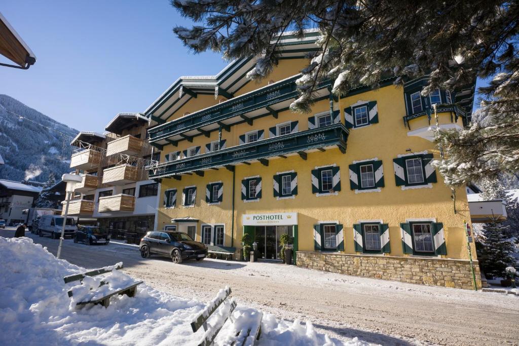 a yellow building with a car parked in front of it at Postresidenz in Mayrhofen