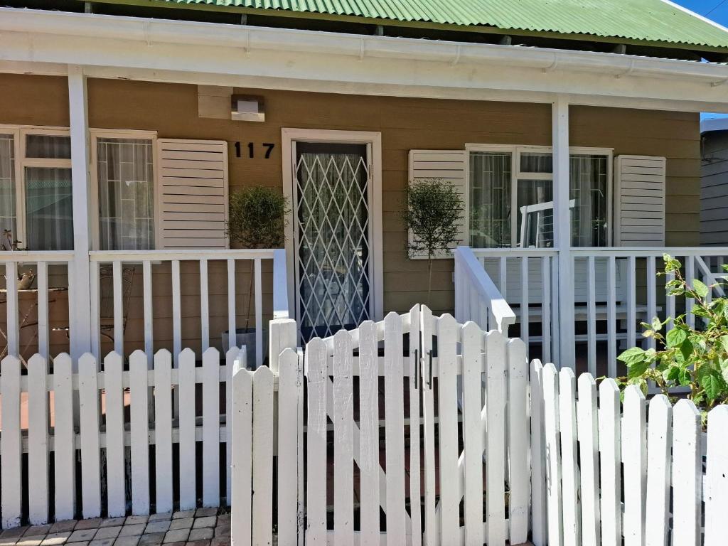a white picket fence in front of a house at 117 De Hollandsche Molen in Hou Moed