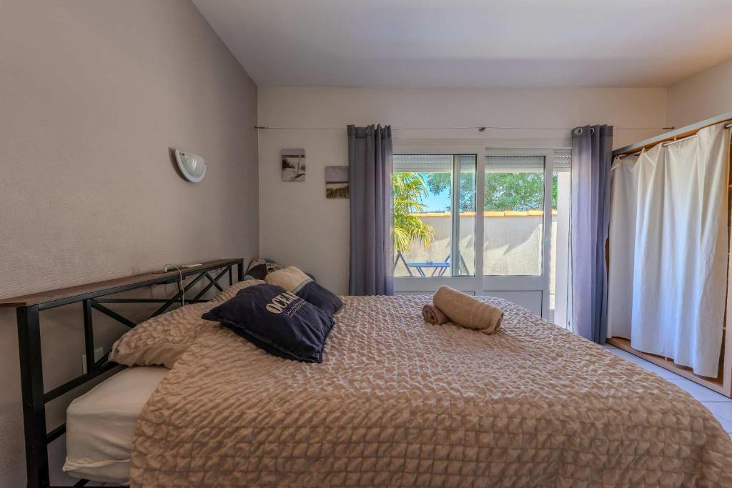a bedroom with a bed with two pillows on it at AppartHotel le Nid Marin in Aytré