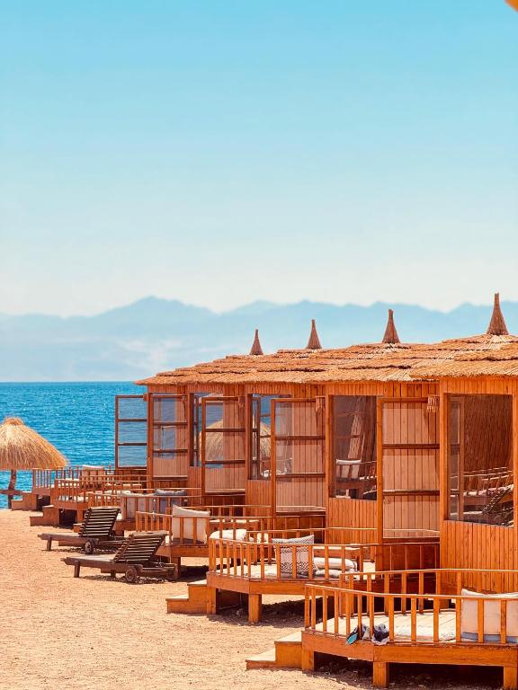 a row of wooden huts on the beach at Nour camp in Nuweiba