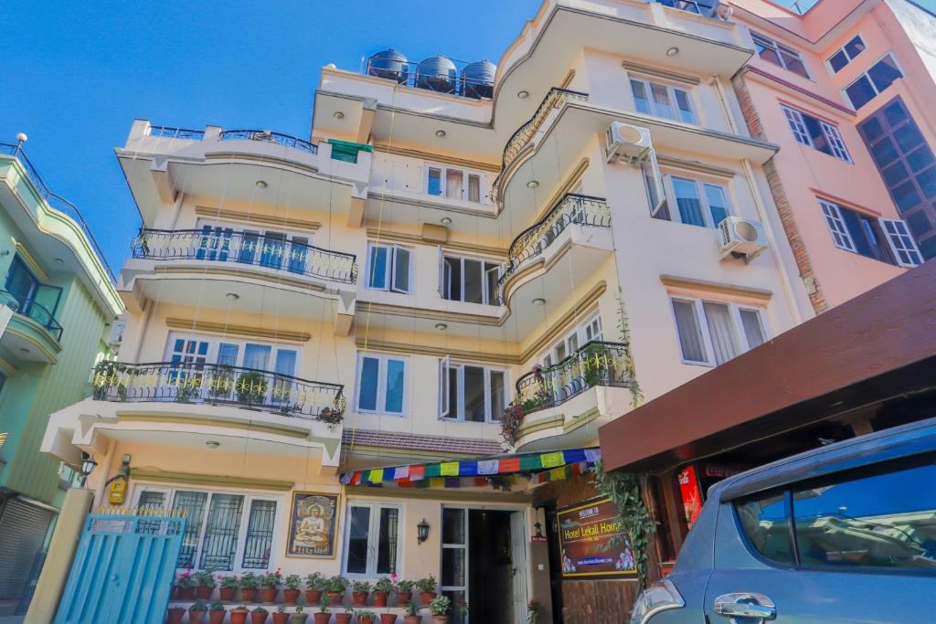 a tall white building with balconies on a street at Hotel Lekali Homes in Kathmandu