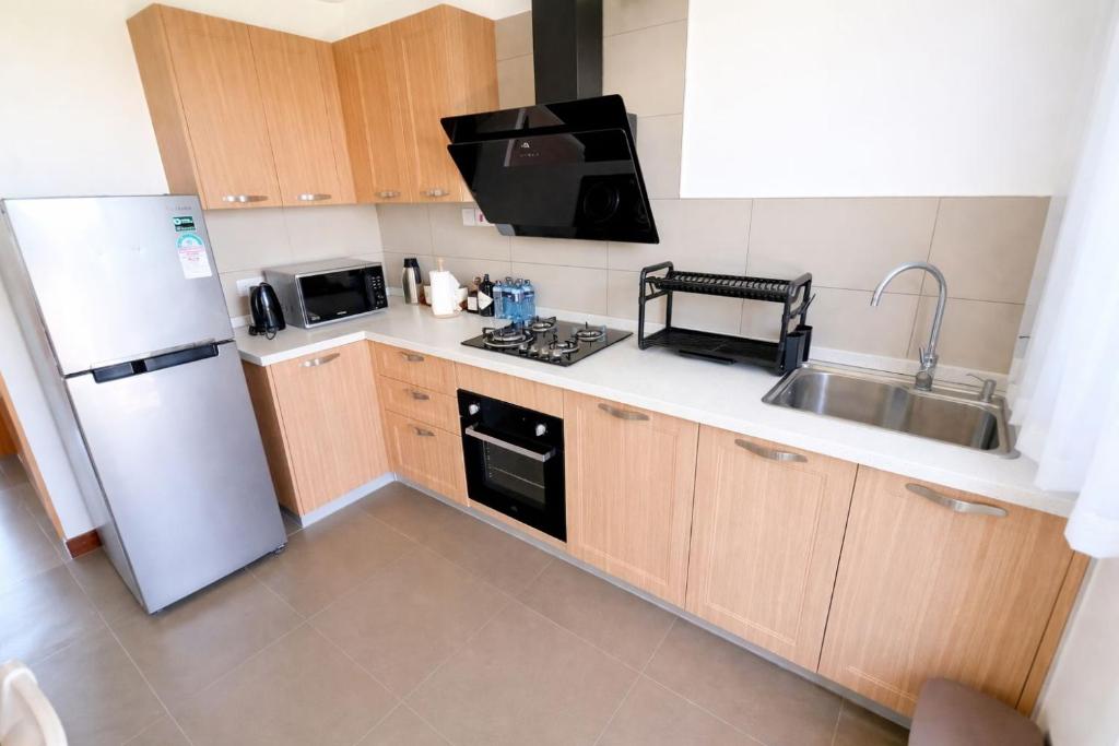 a small kitchen with a sink and a refrigerator at Sultan palace Luxury Two bedrooms in Kilifi