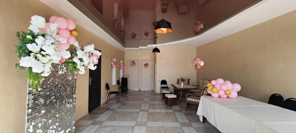 a hallway with tables and flowers in a room at Nino in Kaspi