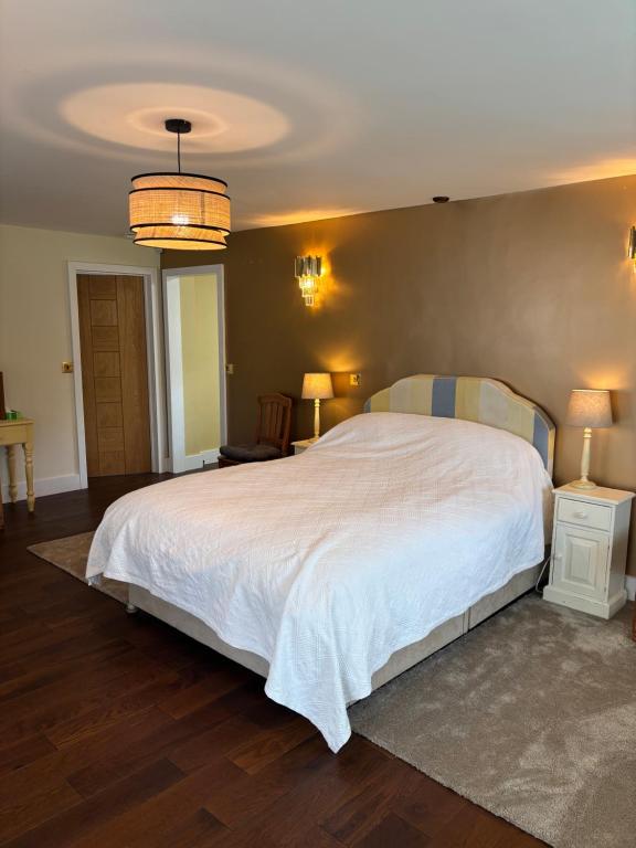 a bedroom with a large white bed and two lamps at Boycott House in Shalstone