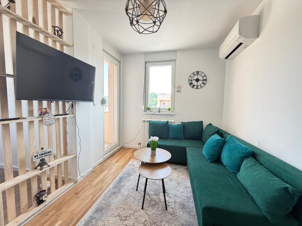 a living room with a green couch and a table at Apartment Alto in Sarajevo