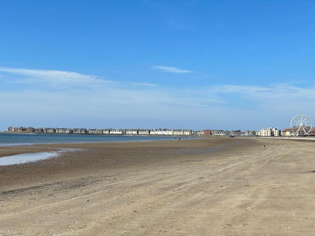 a view of the beach with buildings in the background at Dunes Apartment Troon in Troon