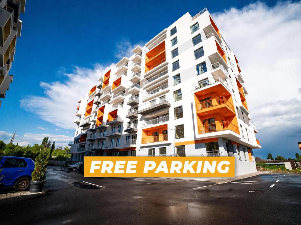 a apartment building with a free parking sign in a parking lot at Real Resort in Ploieşti