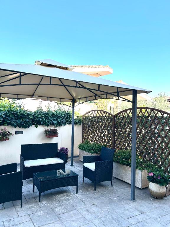 a patio umbrella with chairs and a table at B&B Il Viaggiatore in Tortolì