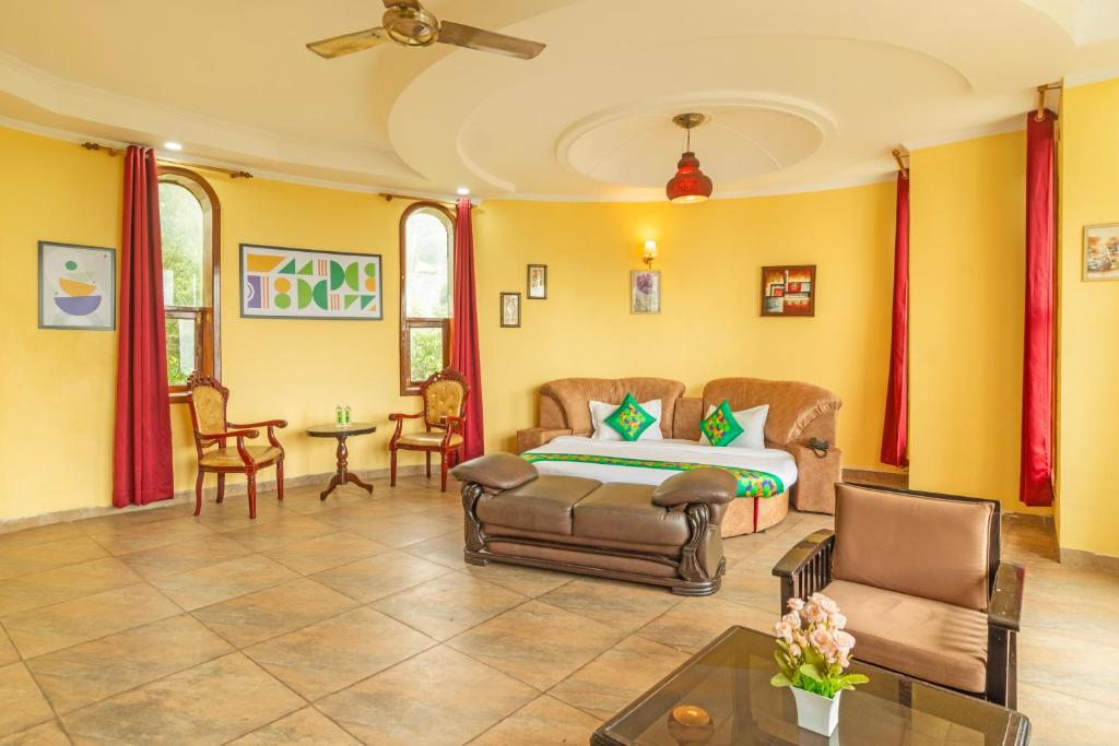a living room with a bed and chairs and a table at Treebo Kaler Hotel & Resorts in Nainital