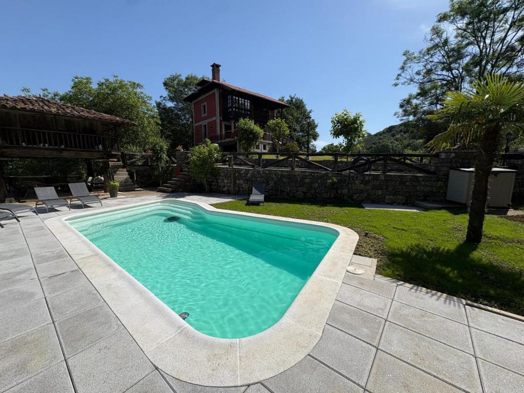 a swimming pool in a yard next to a house at Casa Escuela de Torín - La Casona de Torin in Torín