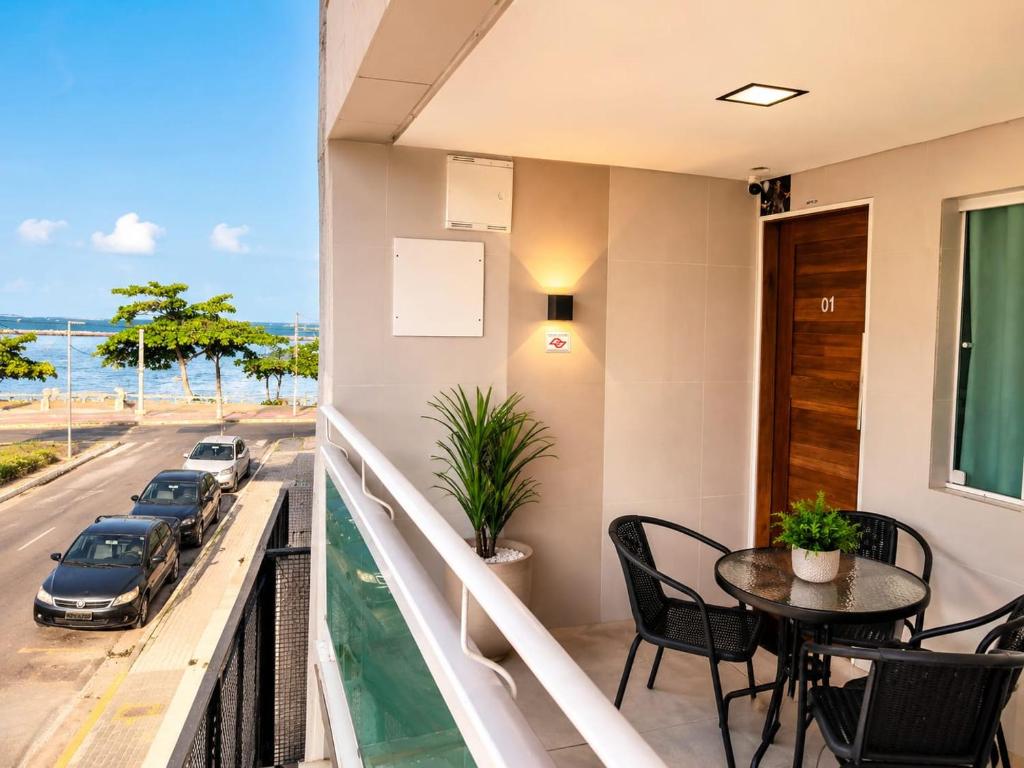 a balcony with a table and chairs and a view of a street at Flats Olinda Vista Mar in Olinda