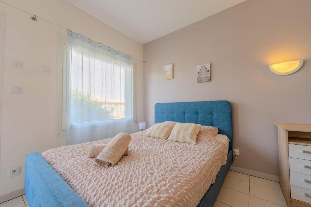a bedroom with a blue bed and a window at Appart-Hotel du drapeau bleu Residence Kiwi in Aytré
