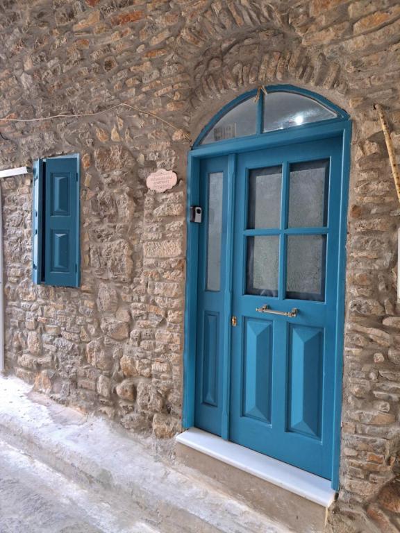 a blue door and window on a stone wall at Patasa holiday apartment in Pyrgi