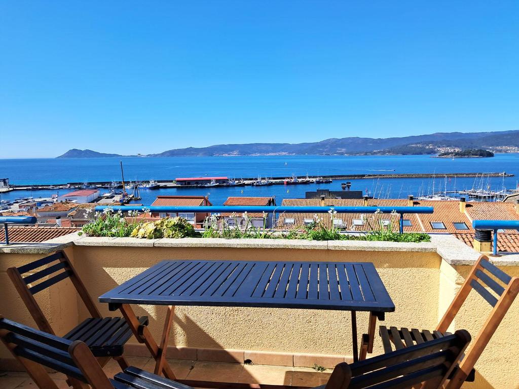 a table and chairs on a balcony with a view of the water at Bella Vista in Portosin