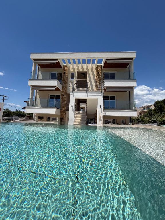 a building with a pool of water in front of it at Azulic Suites Nikiti in Nikiti
