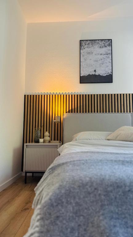 a bedroom with a bed and a striped wall at Nord Loft in Langeoog