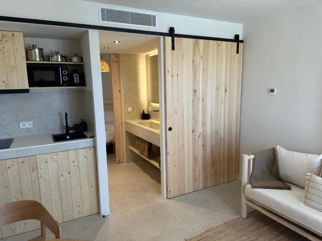 a living room with a sliding door and a kitchen at Apartamentos Eugenio by Formentera Passport in La Savina