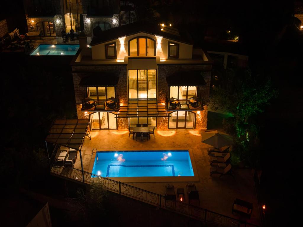 an aerial view of a house with a swimming pool at night at Villa Meltem in Kalkan