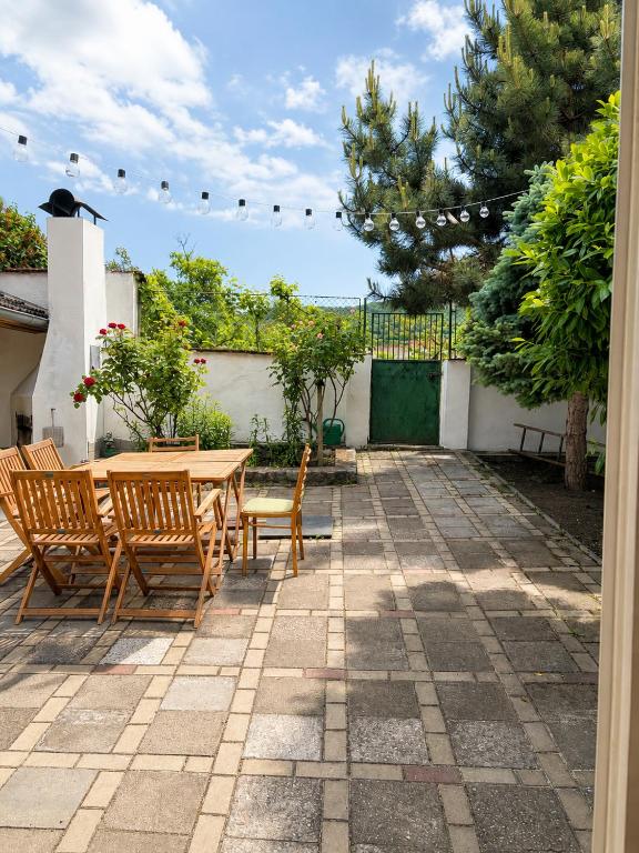 a patio with a wooden table and chairs at Domek u vína in Perná