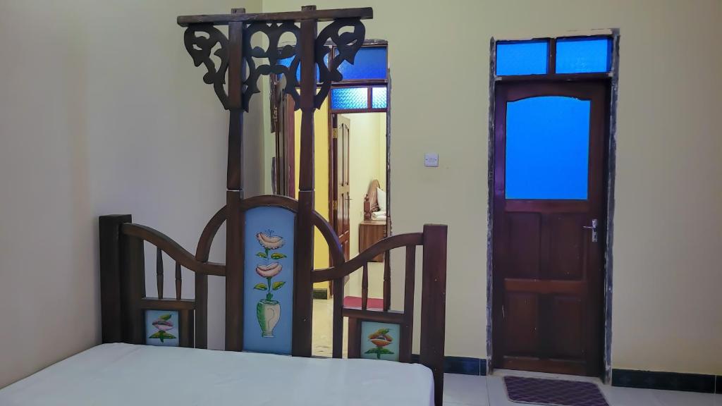 a bedroom with a bed next to a door at WamkHouse in Jambiani