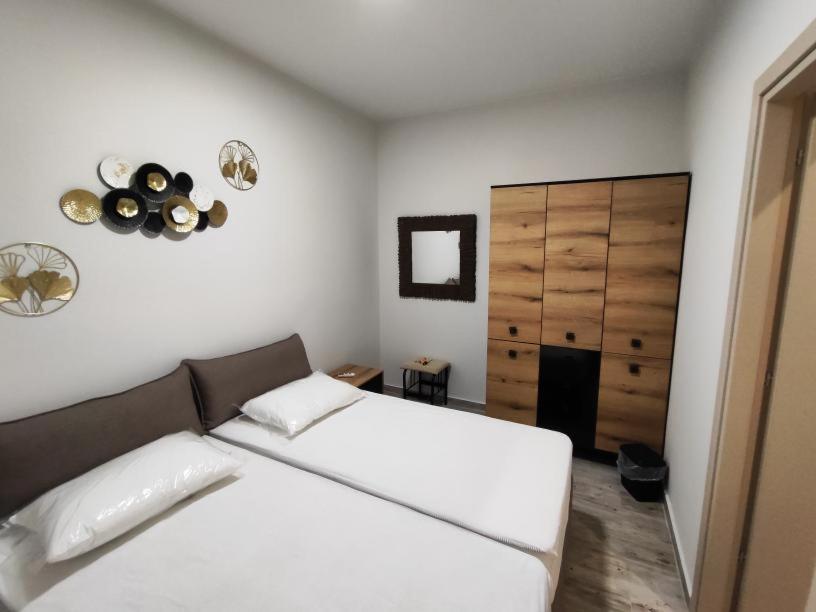 a bedroom with a large white bed and a closet at Savvas's Room in Nea Kallikrateia