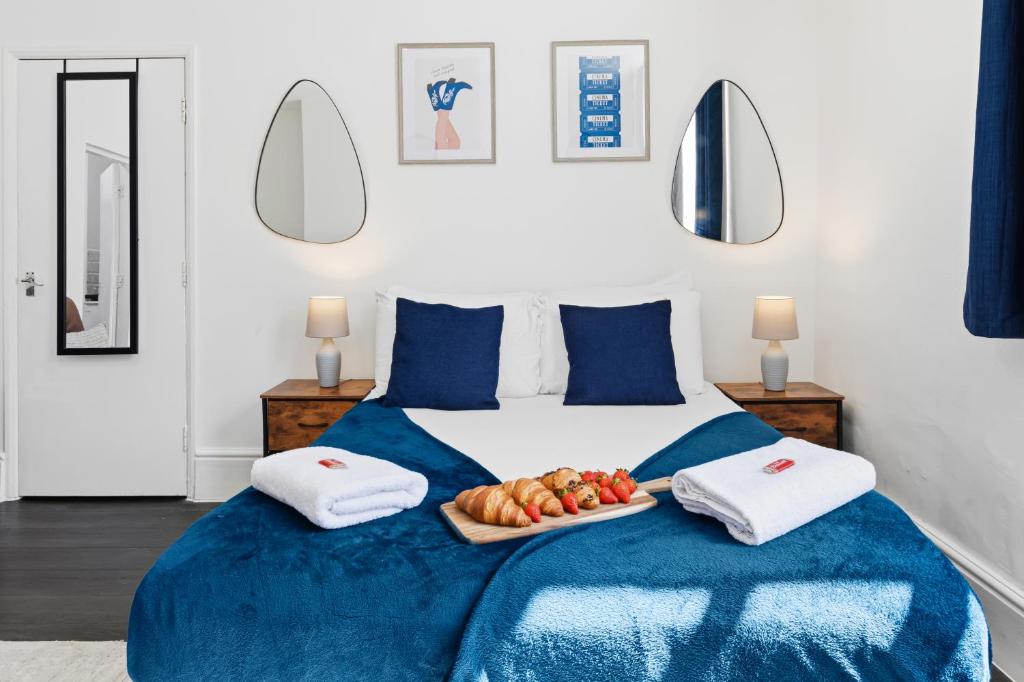 a bedroom with a bed with a tray of fruit on it at Tigris - Cosy Studio Apartment by Traboule Properties Ltd in Warrington