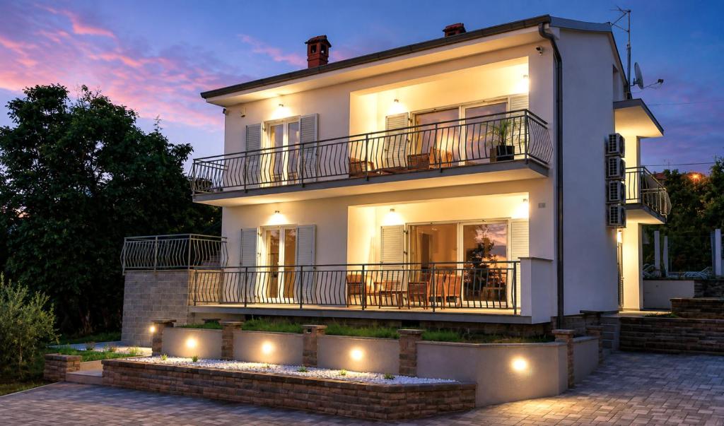 a large white house with lights in front of it at Villa Amoena with Pool and Sauna in Brtonigla